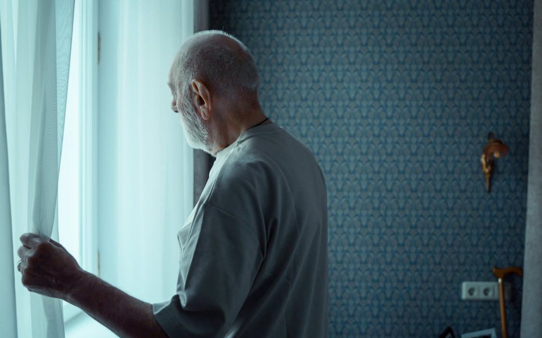 An Elderly Man Opening a Window Curtain