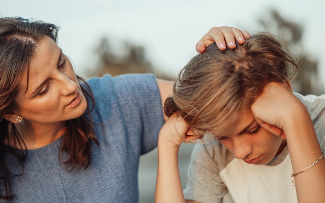 Young boy looks sad as divorcing parents argue behind her and unable to make child arrangements