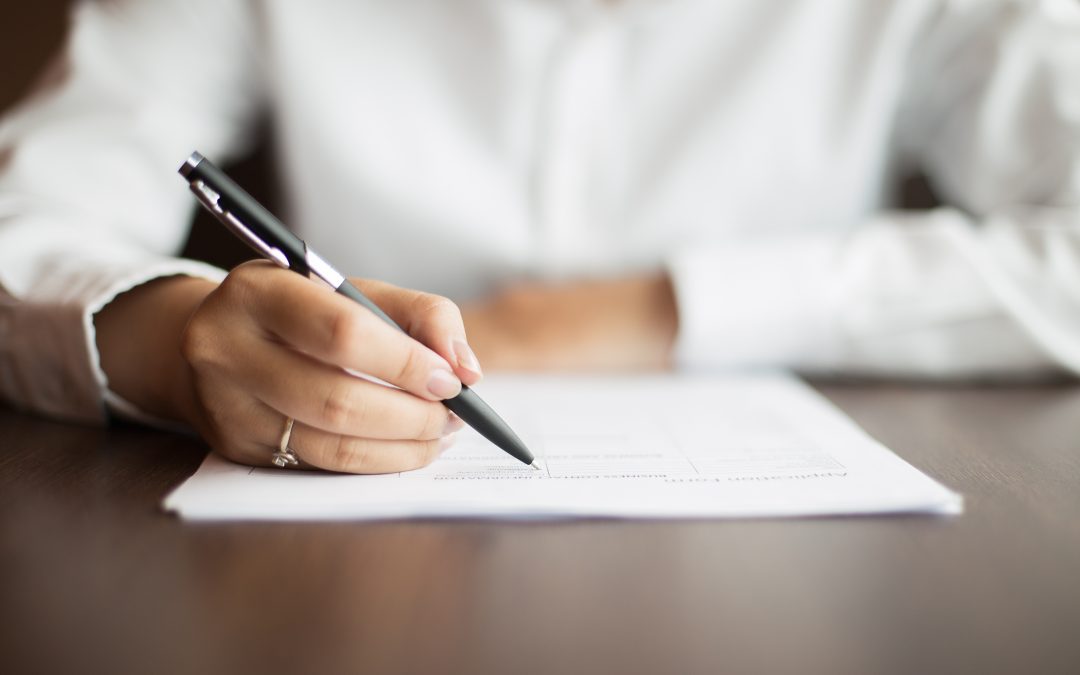Close up of woman signing document dissolving civil partnership